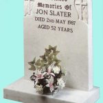 White carved headstone with cross detail